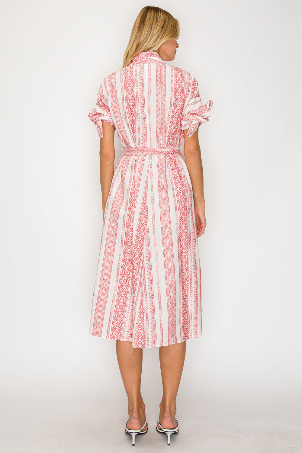 Woman wearing a red and white patterned dress on a white background