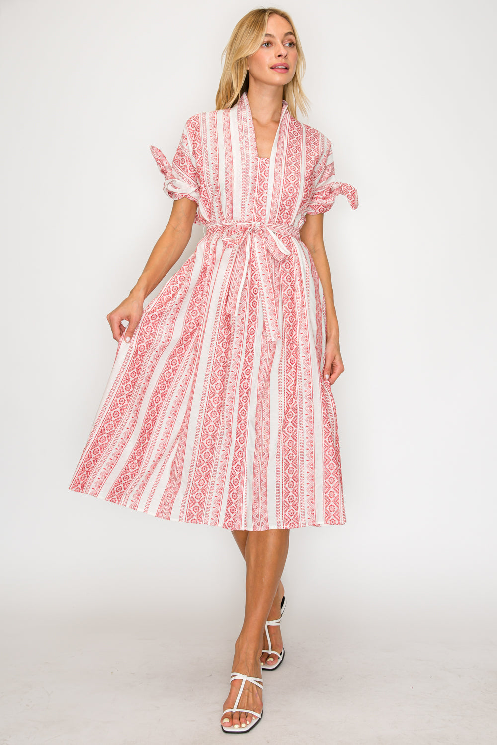 Woman wearing a red and white patterned dress on a white background