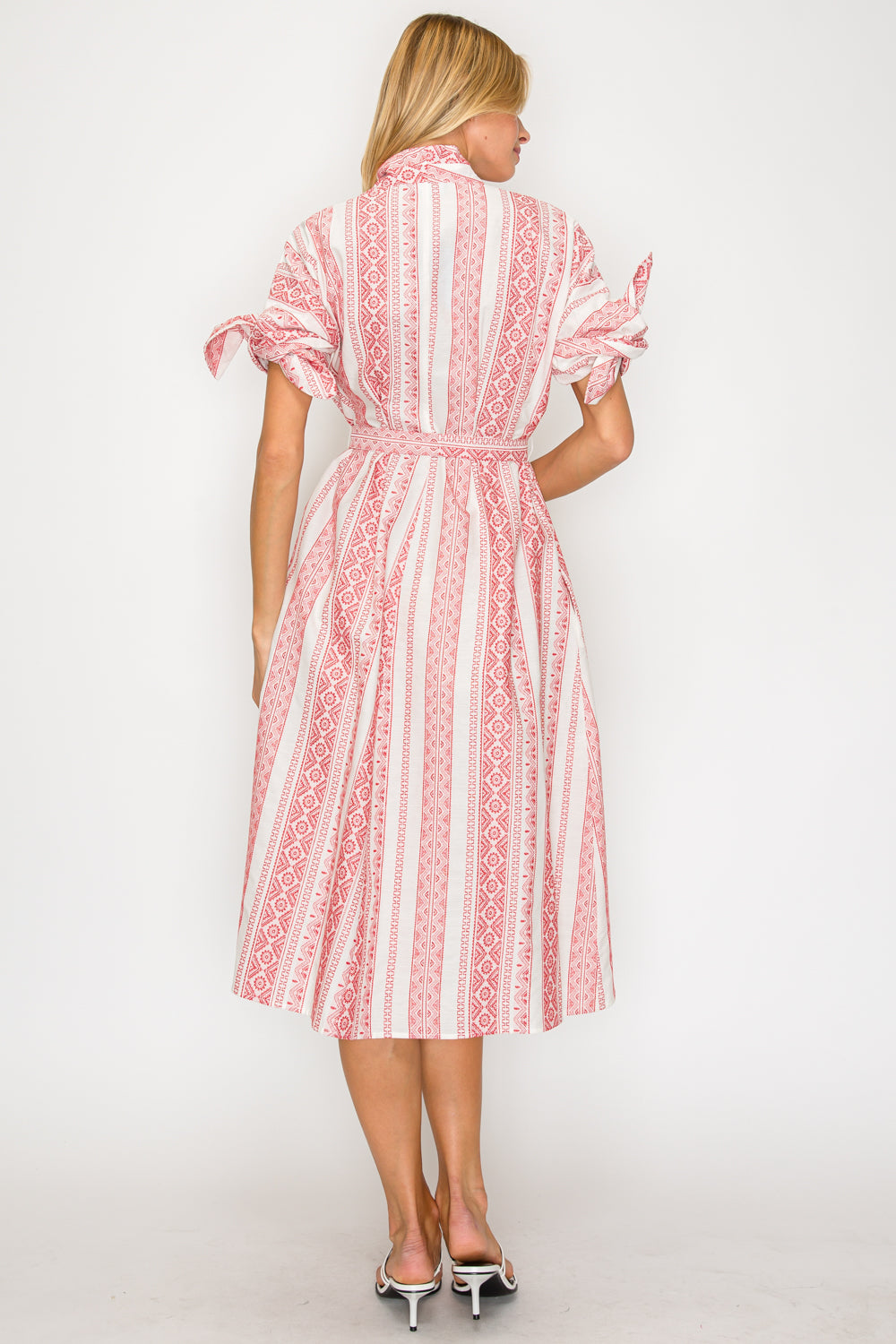 Woman wearing a red and white patterned dress on a white background