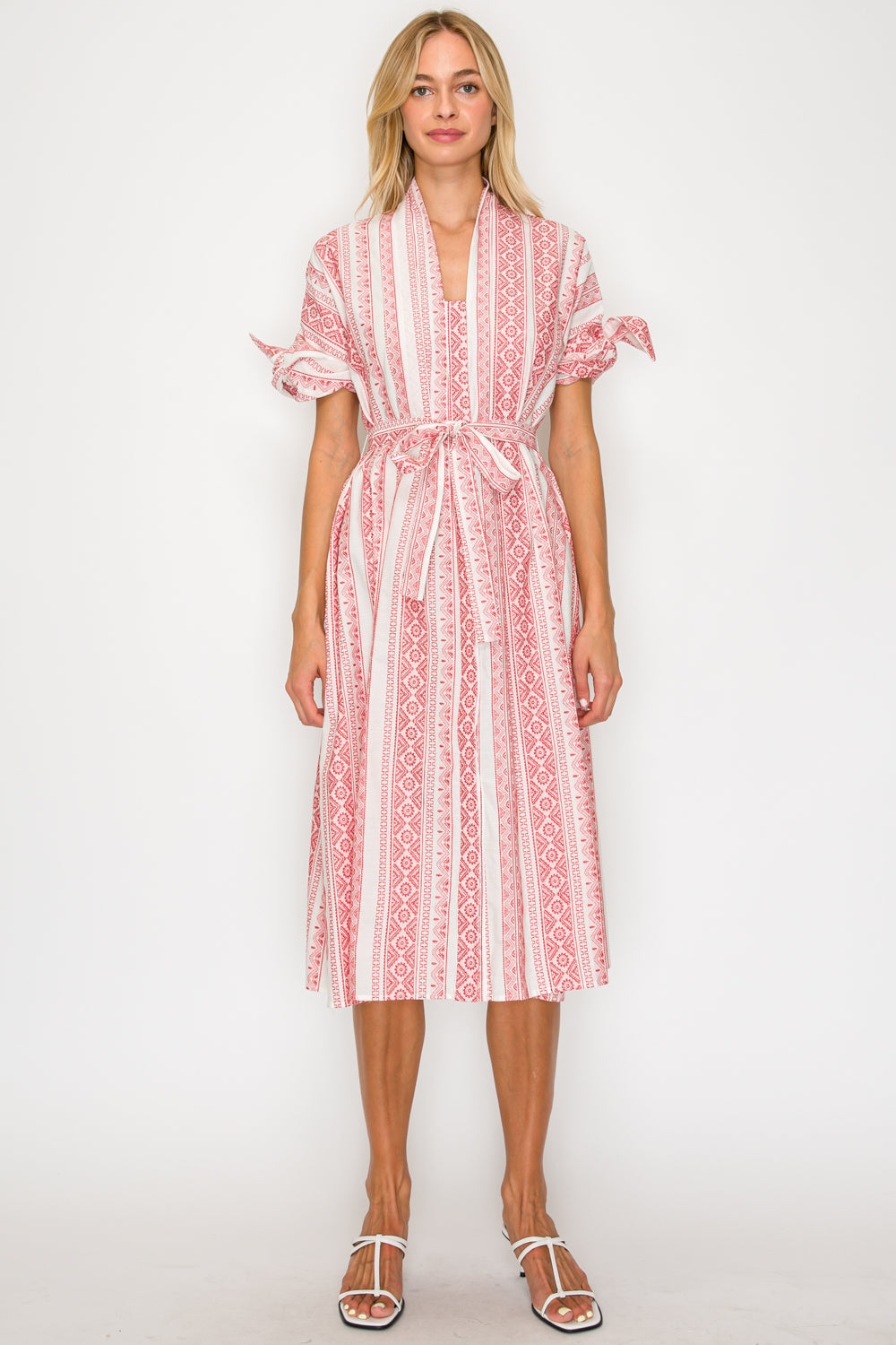 Woman wearing a red and white patterned dress on a white background