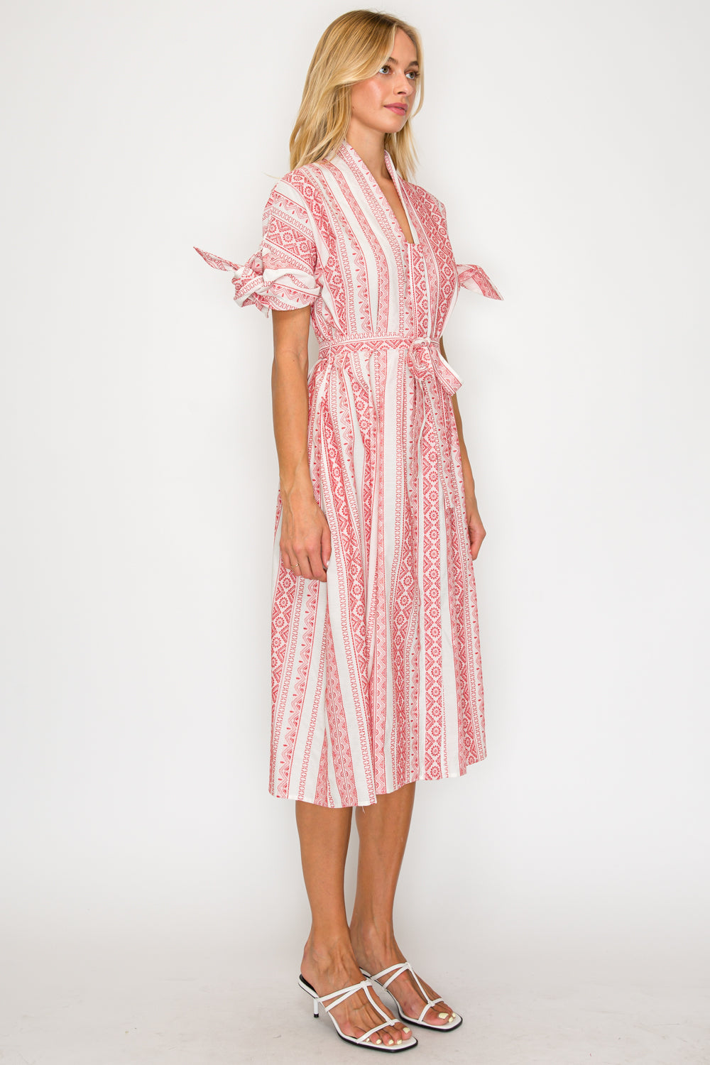Woman wearing a red and white patterned dress on a white background
