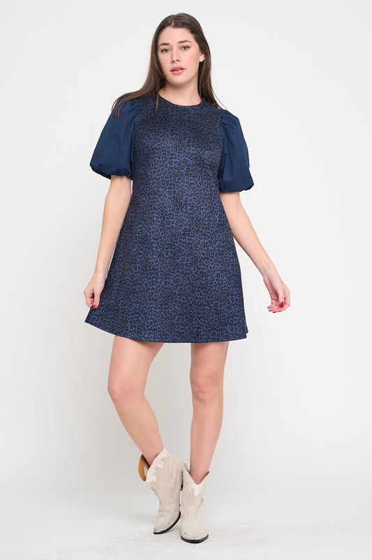 Model wearing a short leopard jacquard dress with puff poplin sleeves and crew neckline
