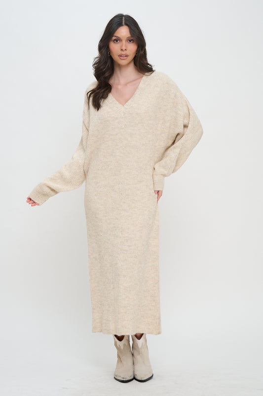 Woman wearing a beige knit maxi sweater dress with a V-neckline, long sleeves, and a relaxed fit, styled with white cowboy boots.