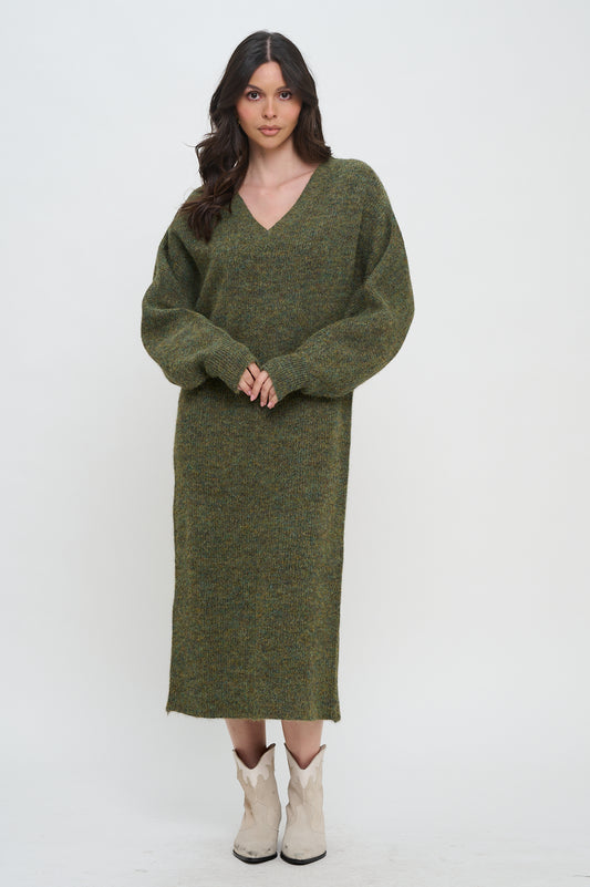 Model wearing an oversized knit sweater maxi dress with V-neckline and balloon sleeves in olive marled fabric, styled with cream boots.