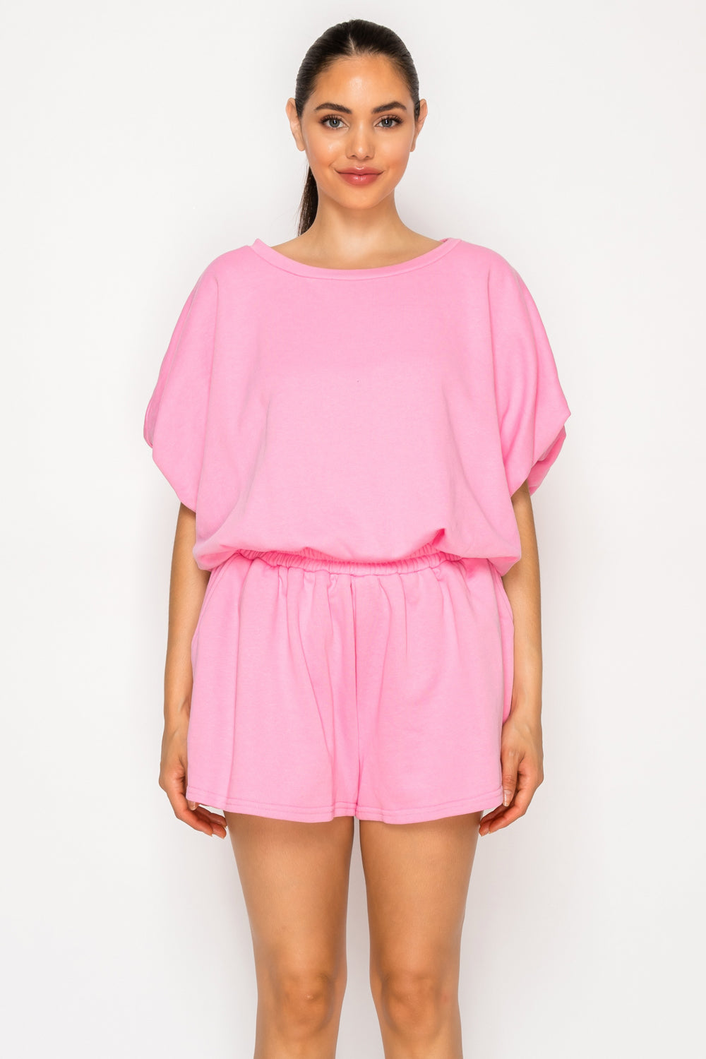 Model wearing the Pink French Terry Set, a two-piece coordinated lounge set featuring a solid pink short-sleeve top and matching elastic-waist shorts.