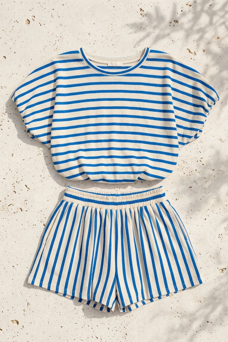 Blue and white striped top and shorts set on a textured beige surface