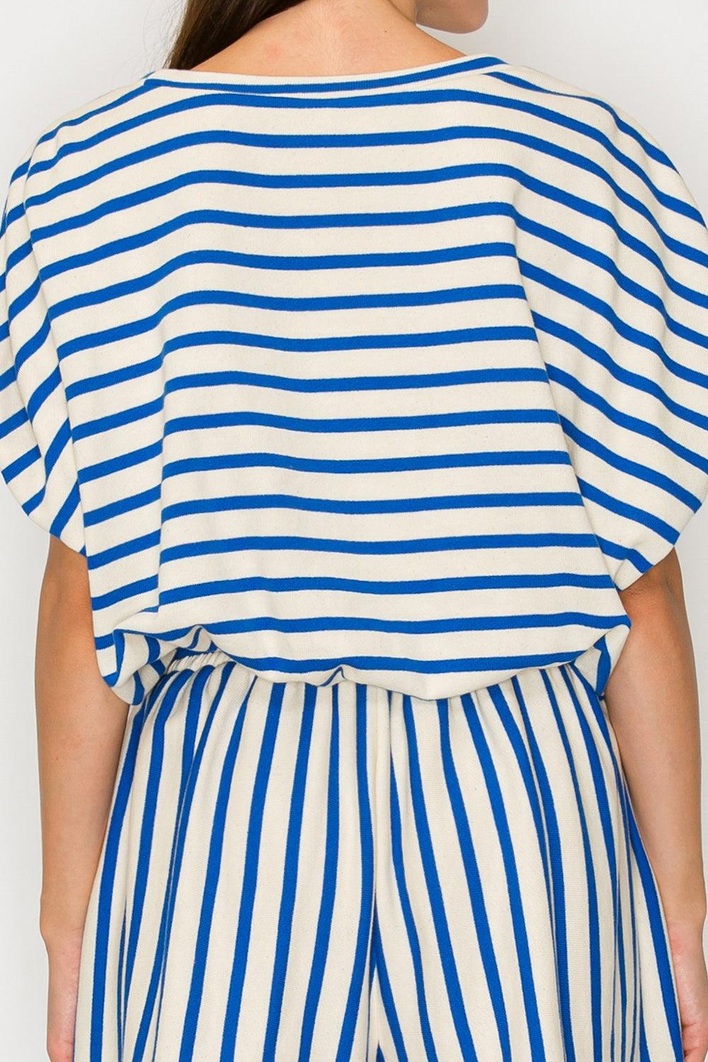 Person wearing a blue and white striped outfit on a plain background