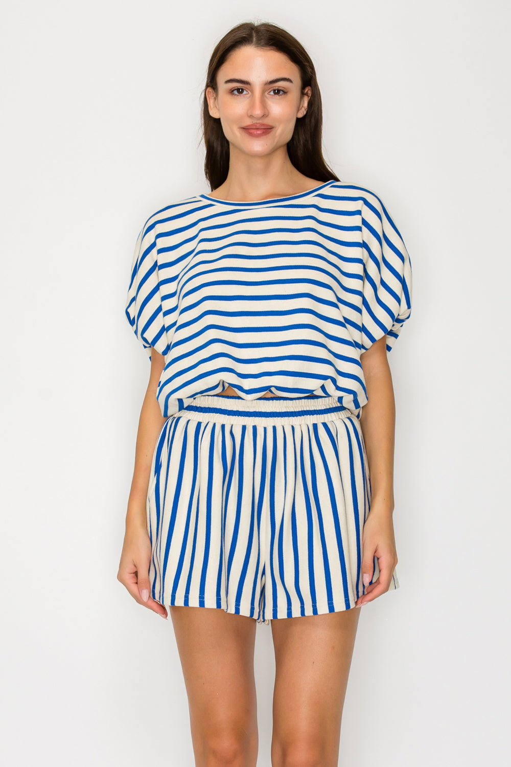 Woman wearing a blue and white striped outfit on a plain background