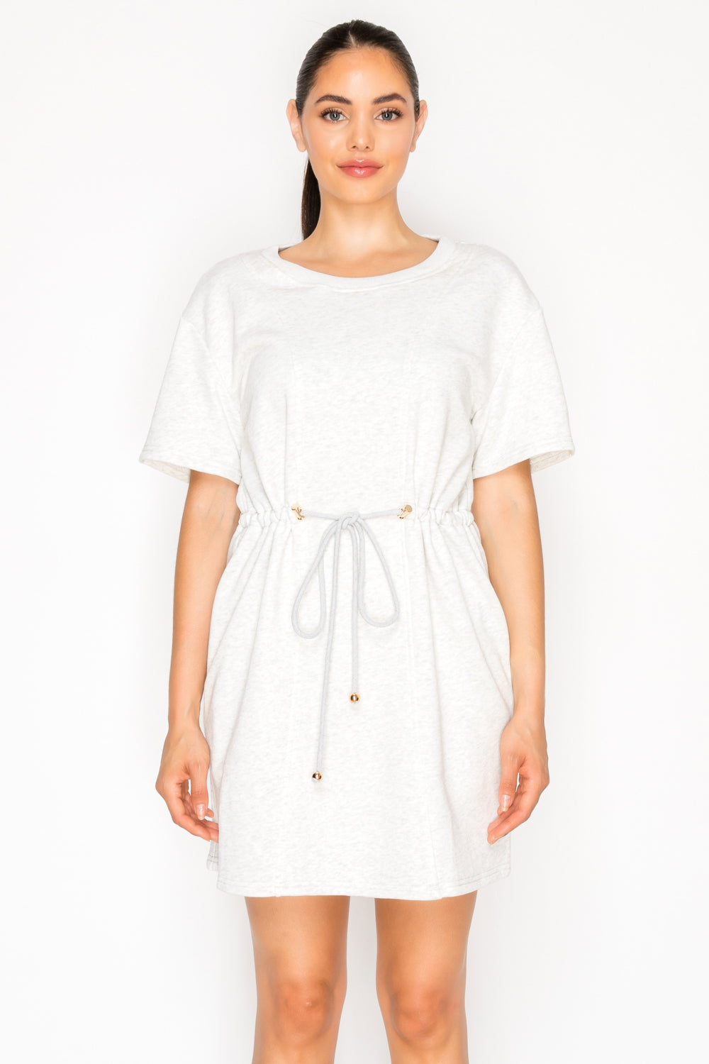 Model wearing the Grey French Terry Short Dress, a t-shirt dress with a round neck, short sleeves, and a rope drawstring waist.