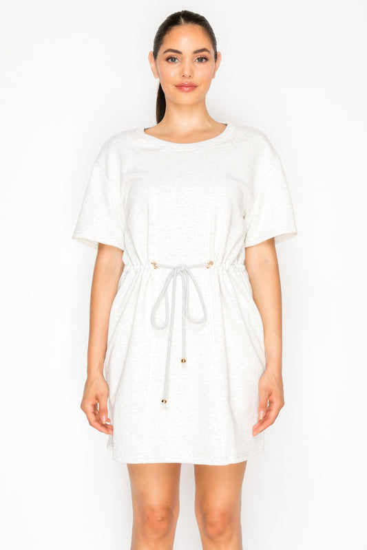 Model wearing the Grey French Terry Short Dress, a t-shirt dress with a round neck, short sleeves, and a rope drawstring waist.