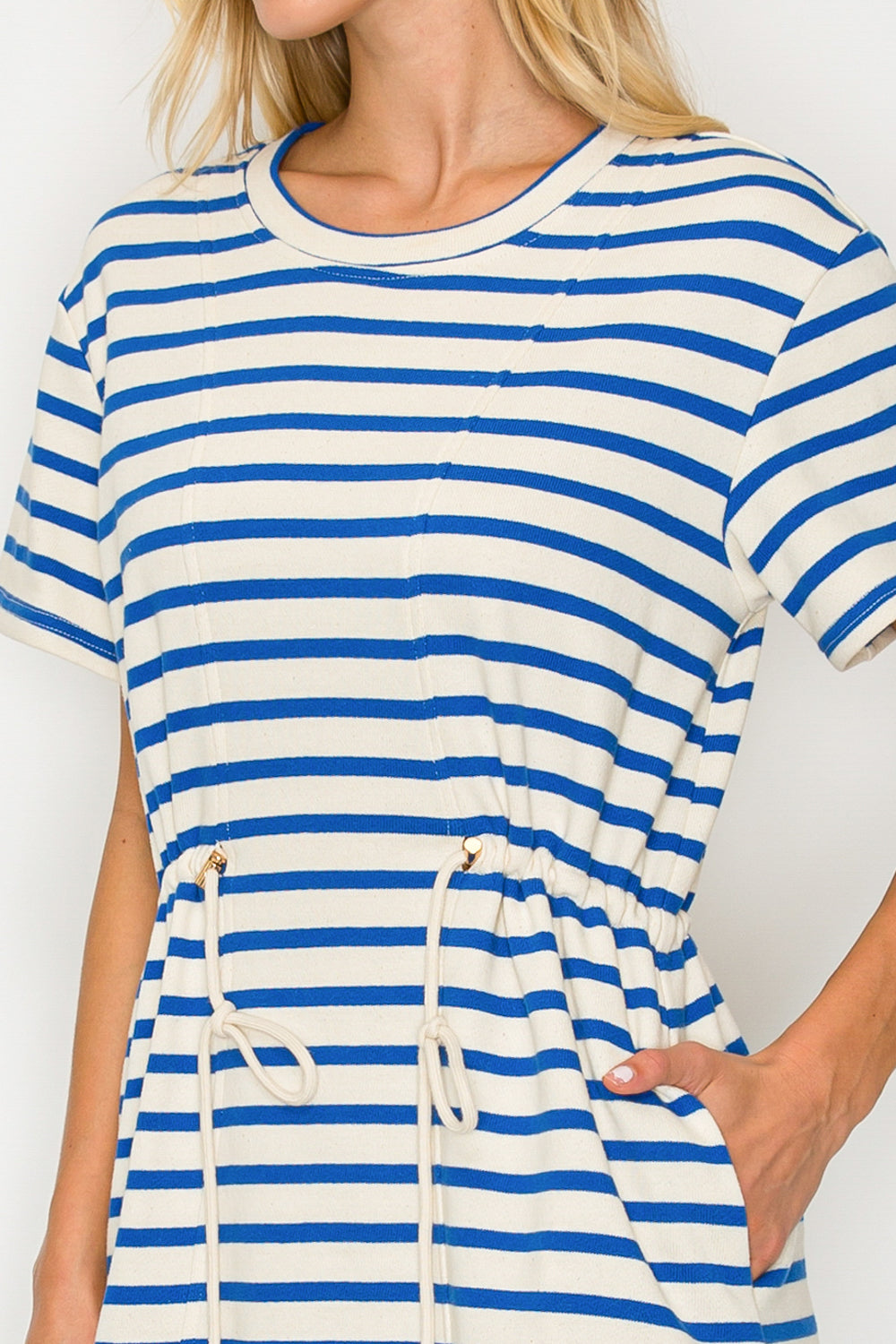 Woman wearing a blue and white striped dress with a white background
