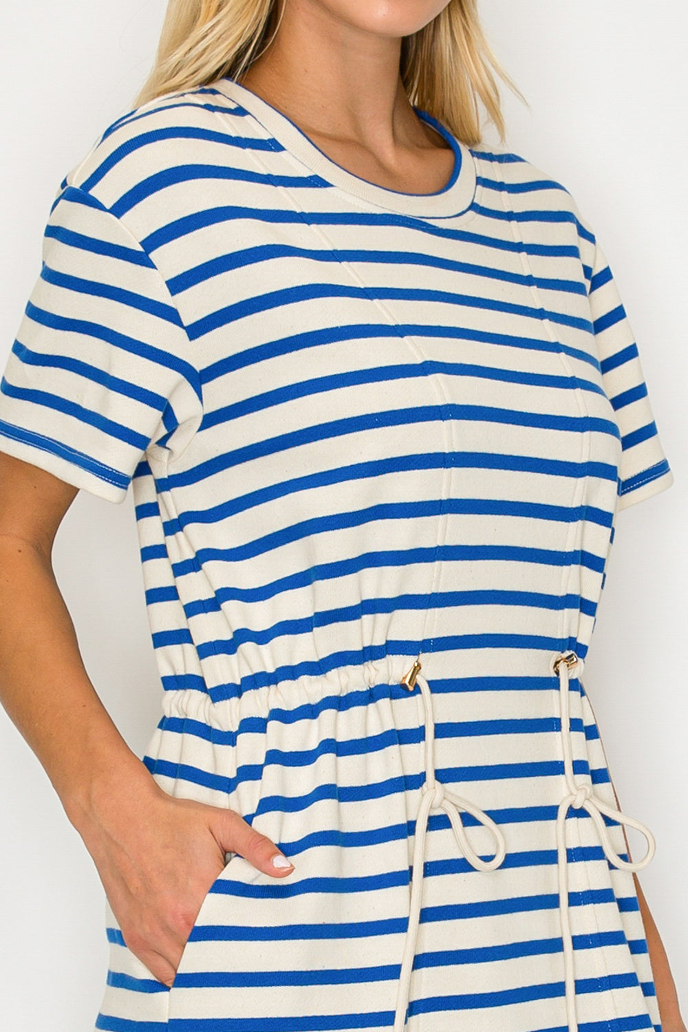 Woman wearing a blue and white striped dress with a plain background