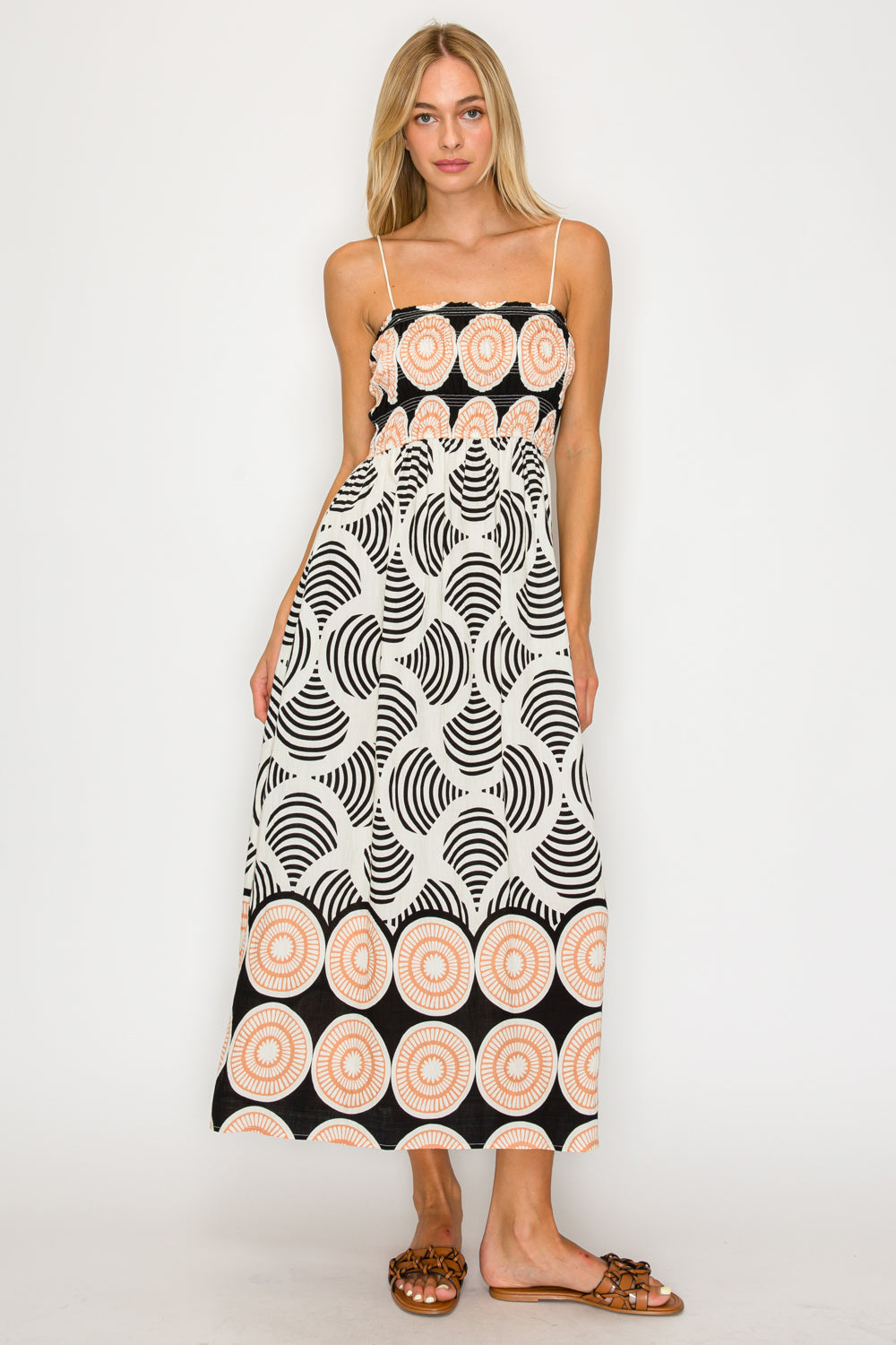 Woman wearing a black and white patterned dress with pink circles on a white background