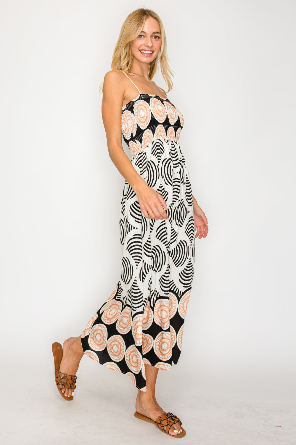 Woman wearing a black and white patterned dress on a white background