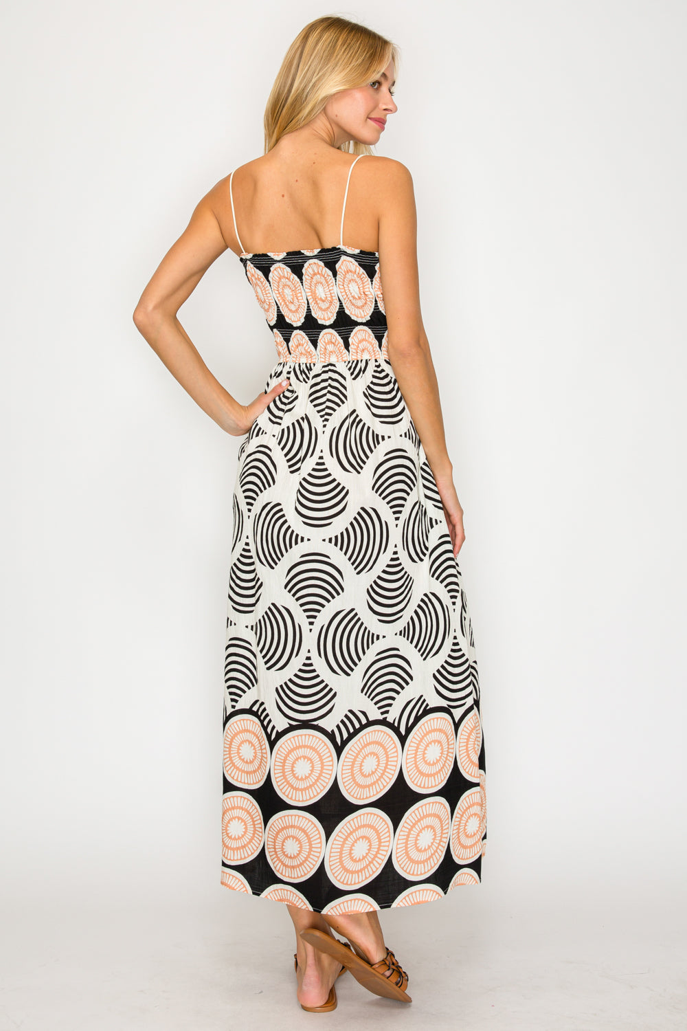 Woman wearing a black and white patterned dress on a white background