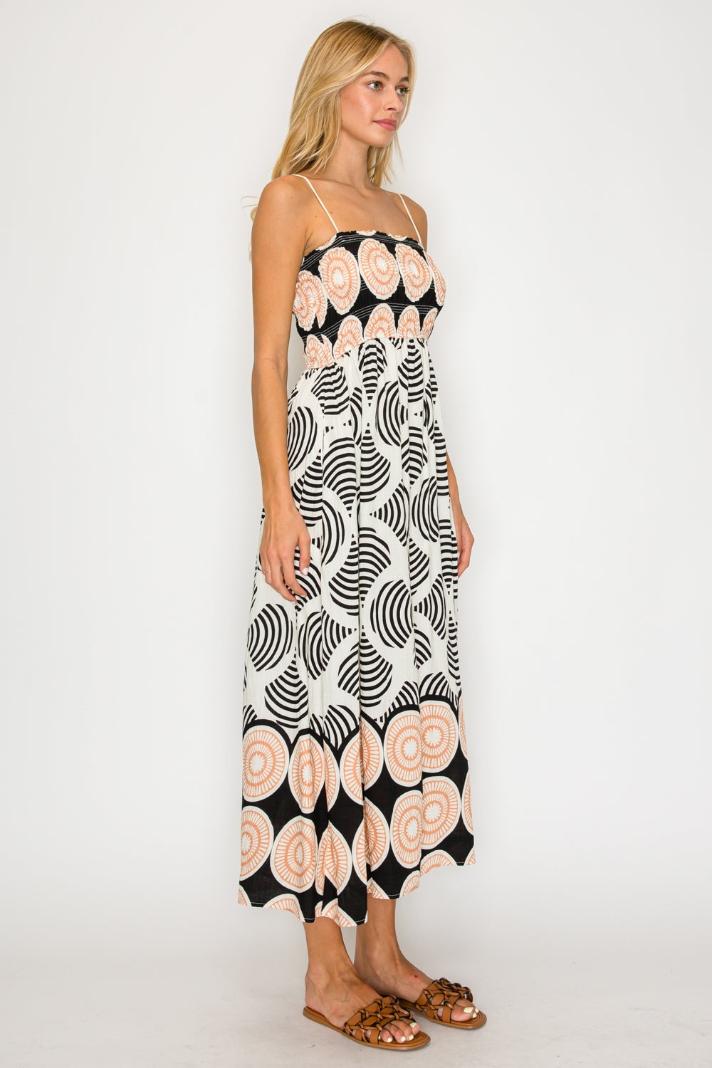 Woman wearing a black and white patterned dress with pink floral design on a white background