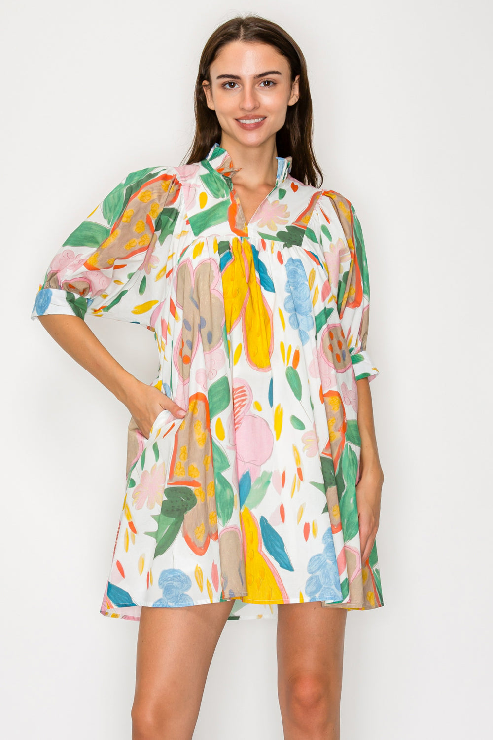 Woman wearing a colorful floral dress against a white background