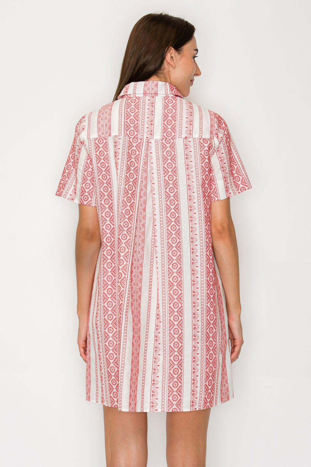 Woman wearing a red and white patterned dress on a white background