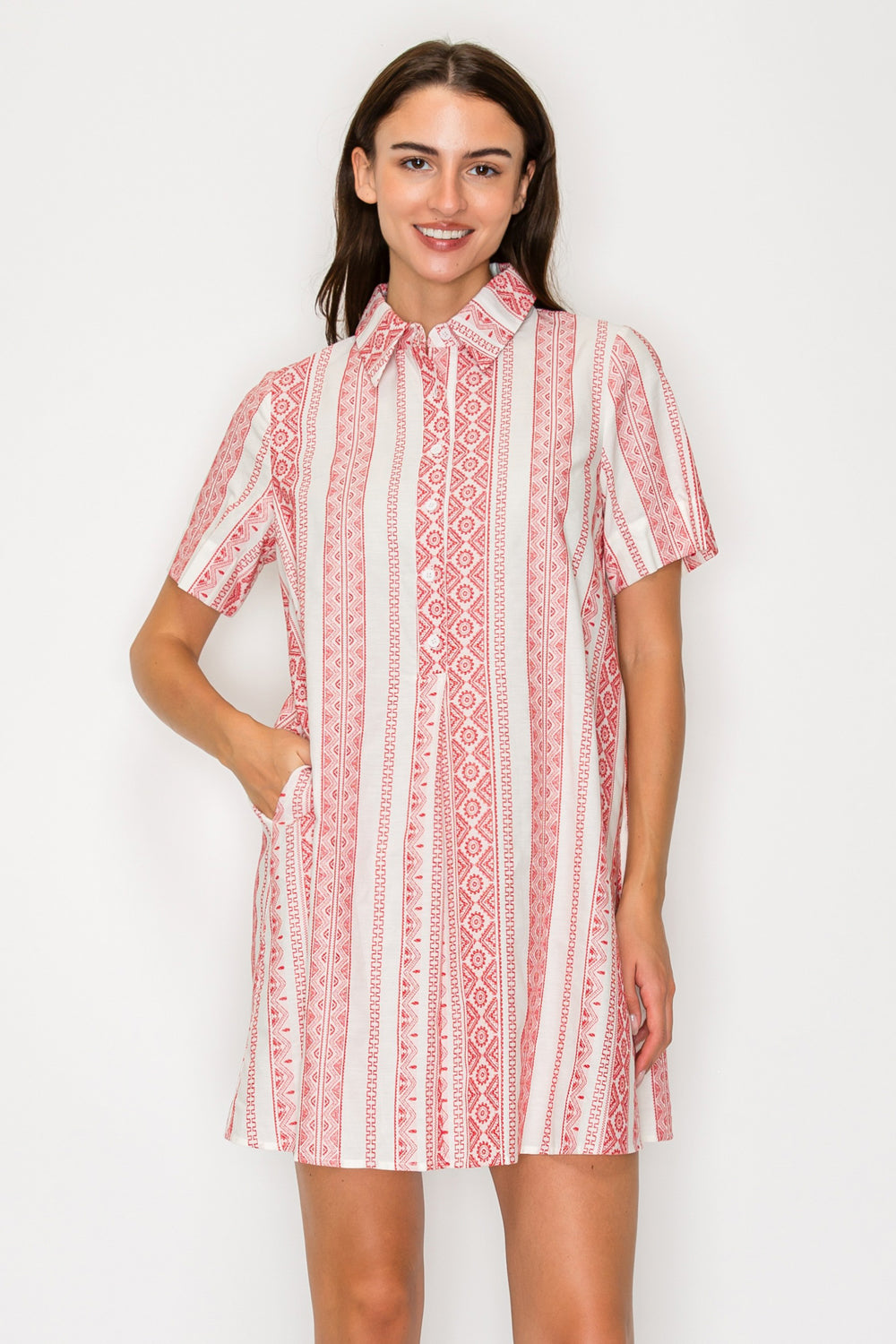 Woman wearing a red and white patterned dress on a white background