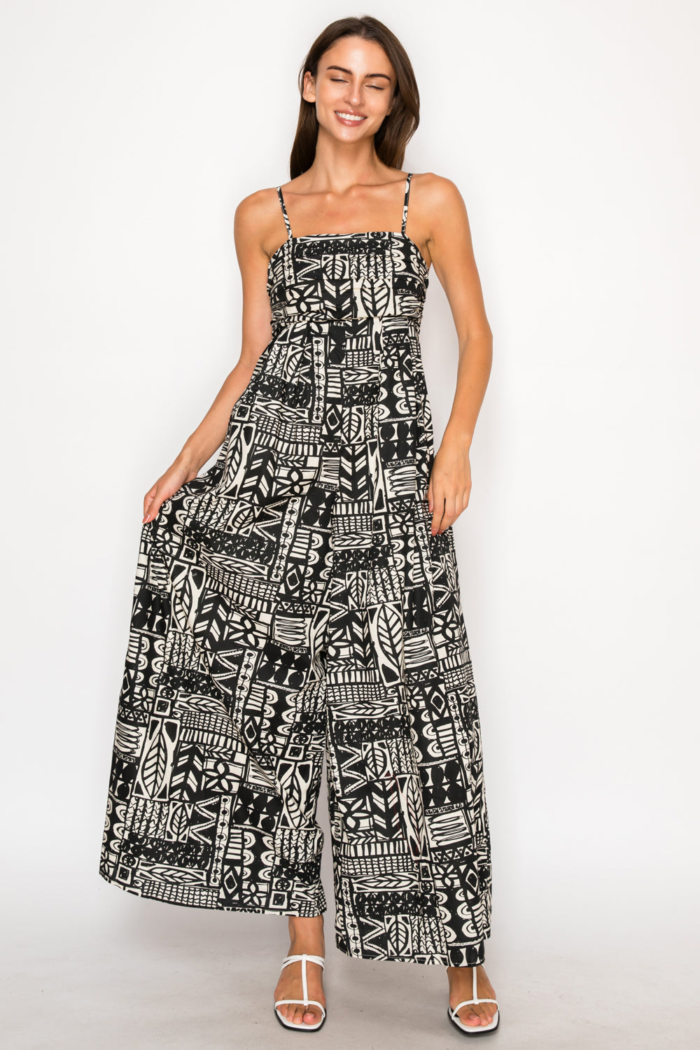 Model wearing the Nysas Ink Maxi Dress, a black and white abstract print dress with a smocked bodice, spaghetti straps, and a tiered skirt.