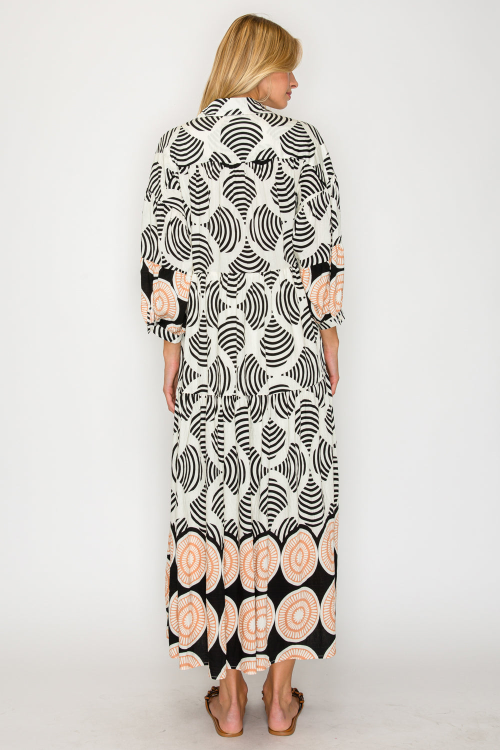 Woman wearing a long, patterned dress on a white background