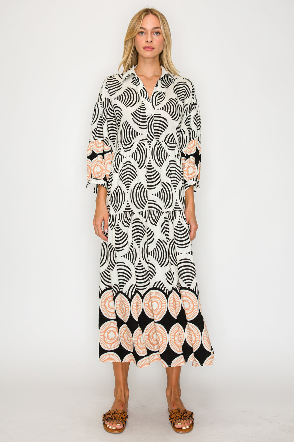 Woman wearing a black and white patterned dress on a white background