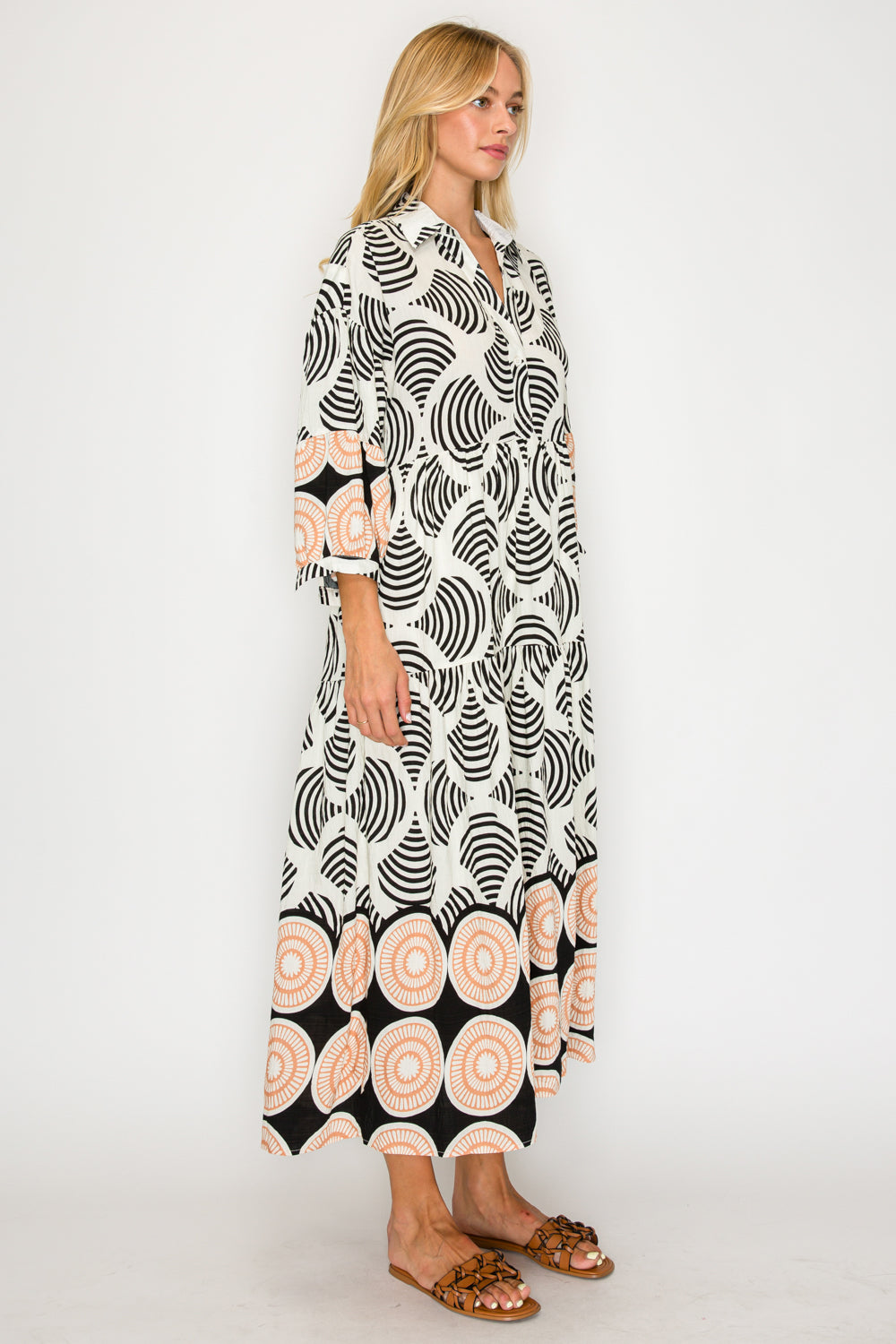 Woman wearing a long, patterned dress on a white background