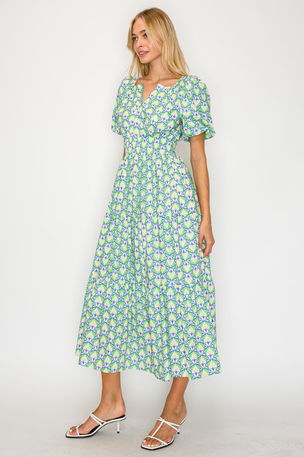 Woman wearing a green floral dress against a white background