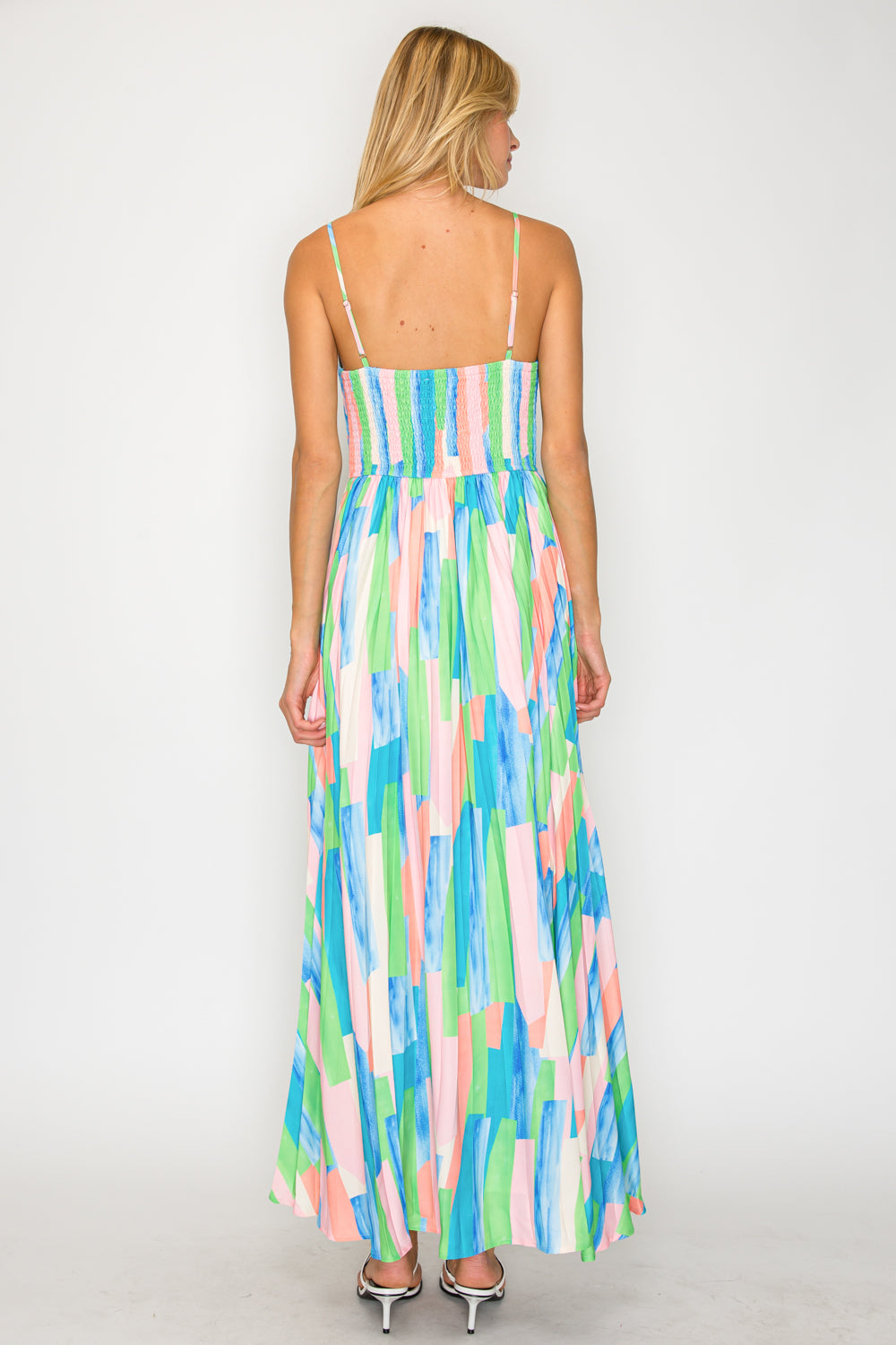 Woman wearing a colorful abstract patterned dress on a white background