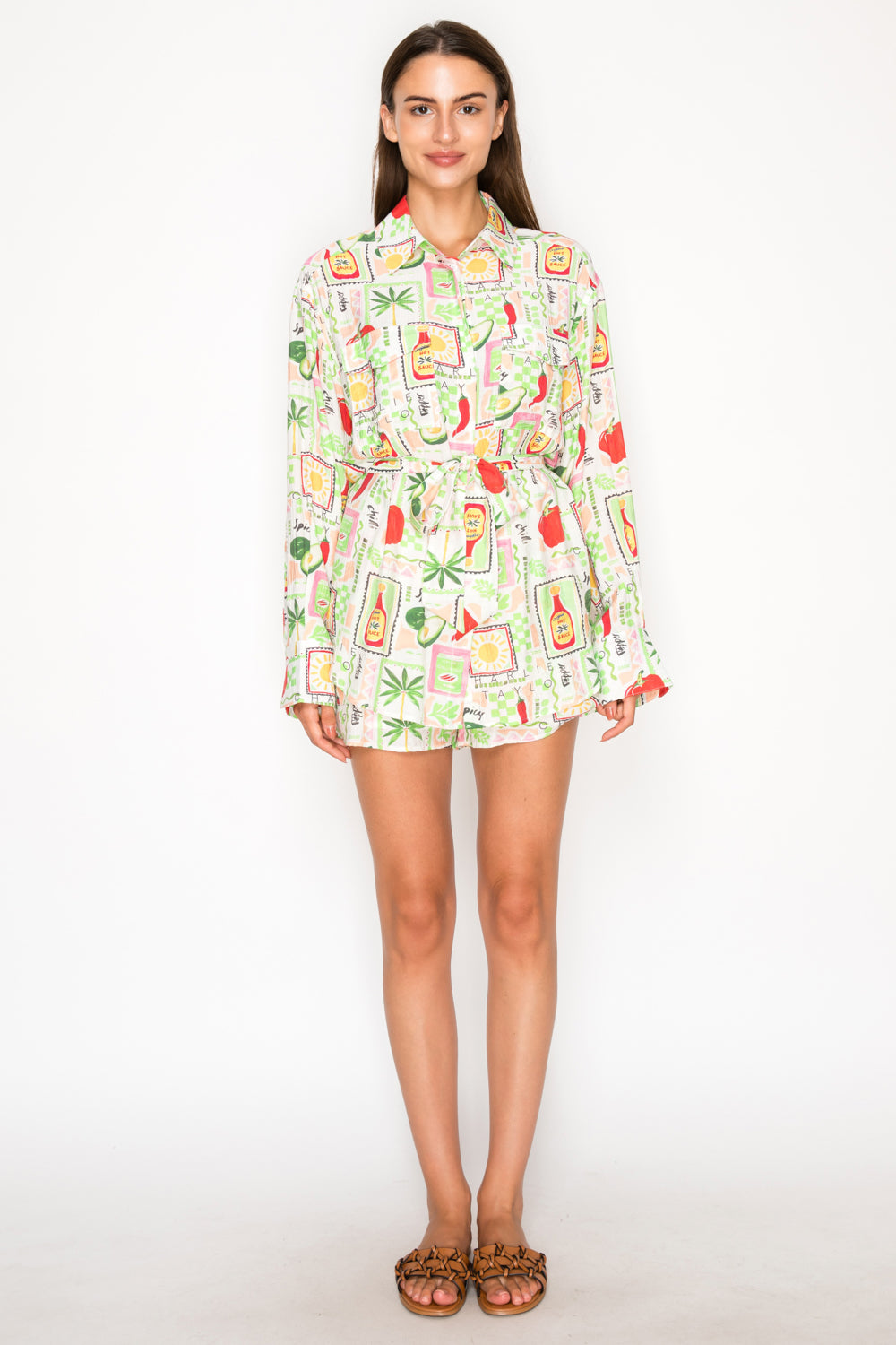 Model wearing the Pepper Parea Tunic Shirt, an oversized white button-down with a colorful chili pepper and avocado graphic print.