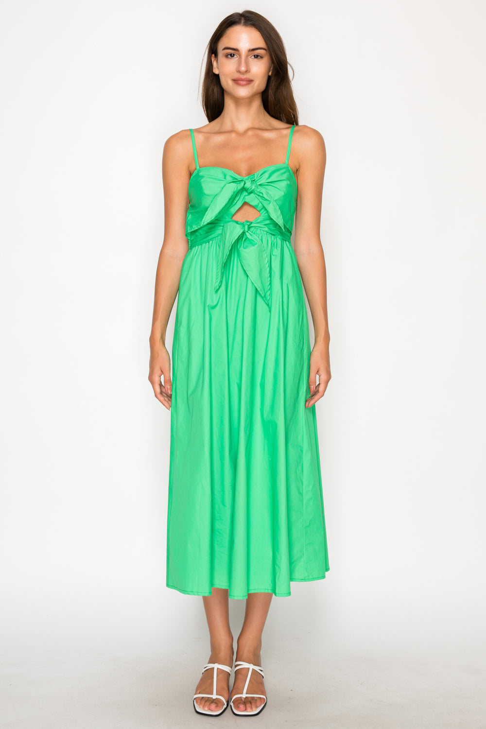 Model wearing the Green Poplin Midi Dress, a vibrant green midi dress with tie-front details, a small cut-out, and adjustable straps.