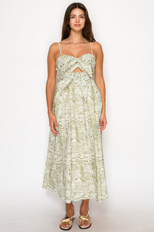 Model wearing the Verdant Bellezza Maxi Dress, a green and cream printed dress with a sweetheart neckline, bust cut-out, and tiered skirt.