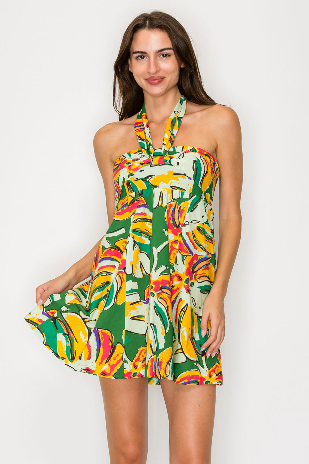 Woman wearing a colorful floral dress against a white background
