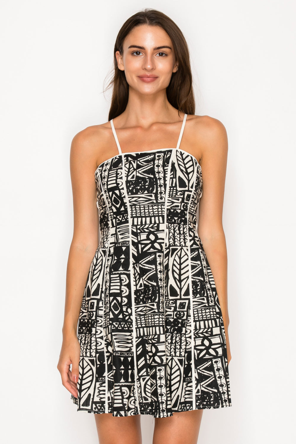 Model wearing the Nysas Ink Mini Dress from Meet Me in Santorini, a black and white abstract print dress with a square neck and spaghetti straps.