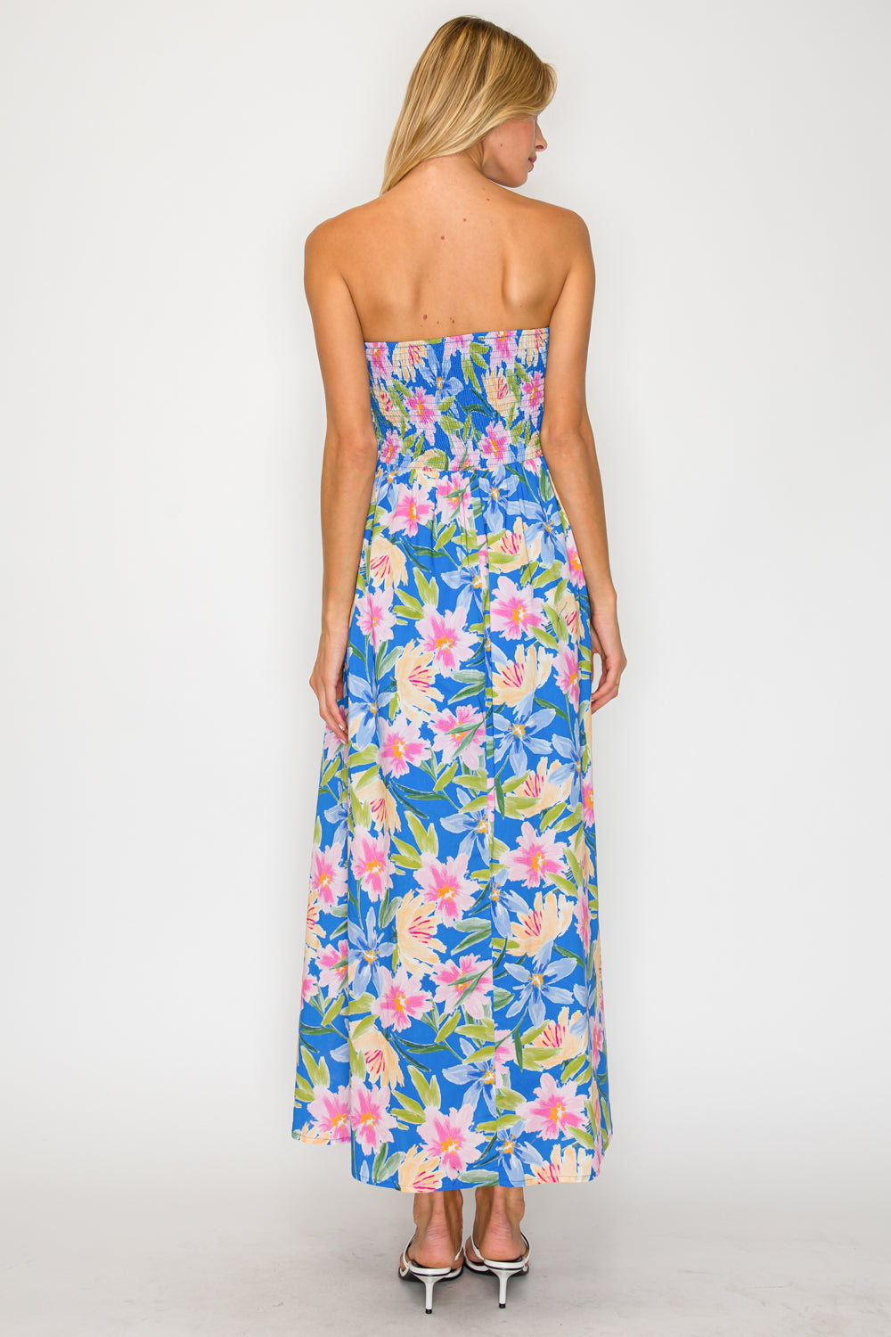 Woman wearing a strapless floral dress on a white background