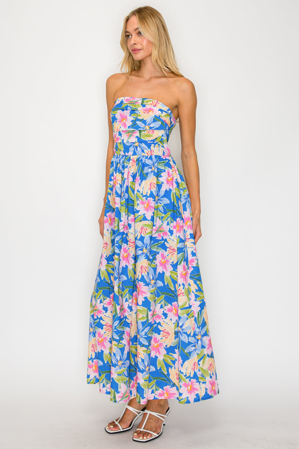 Woman wearing a floral strapless dress on a white background