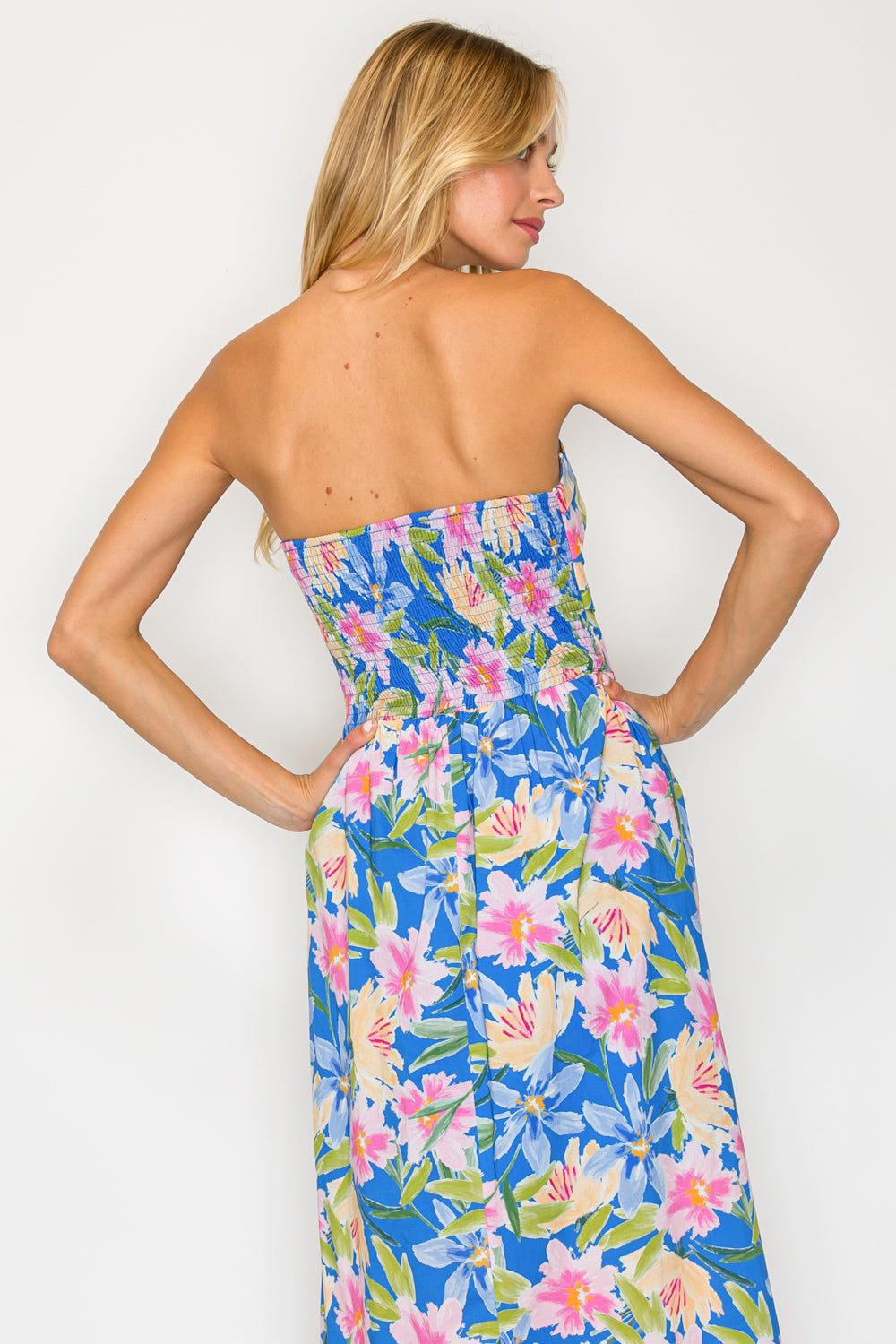 Woman wearing a strapless floral dress on a white background