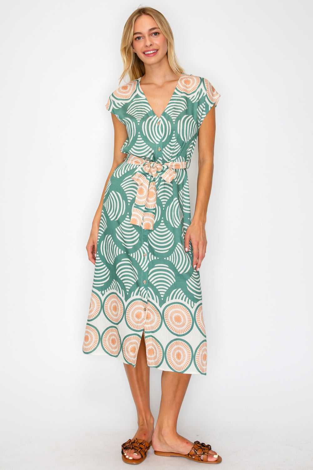 Woman wearing a green patterned dress on a white background