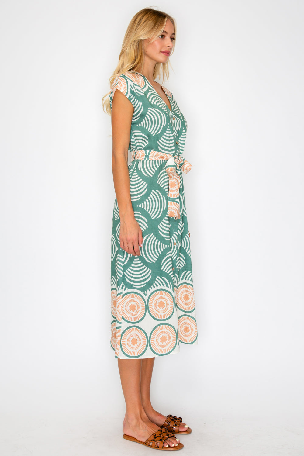 Woman wearing a green patterned dress on a white background