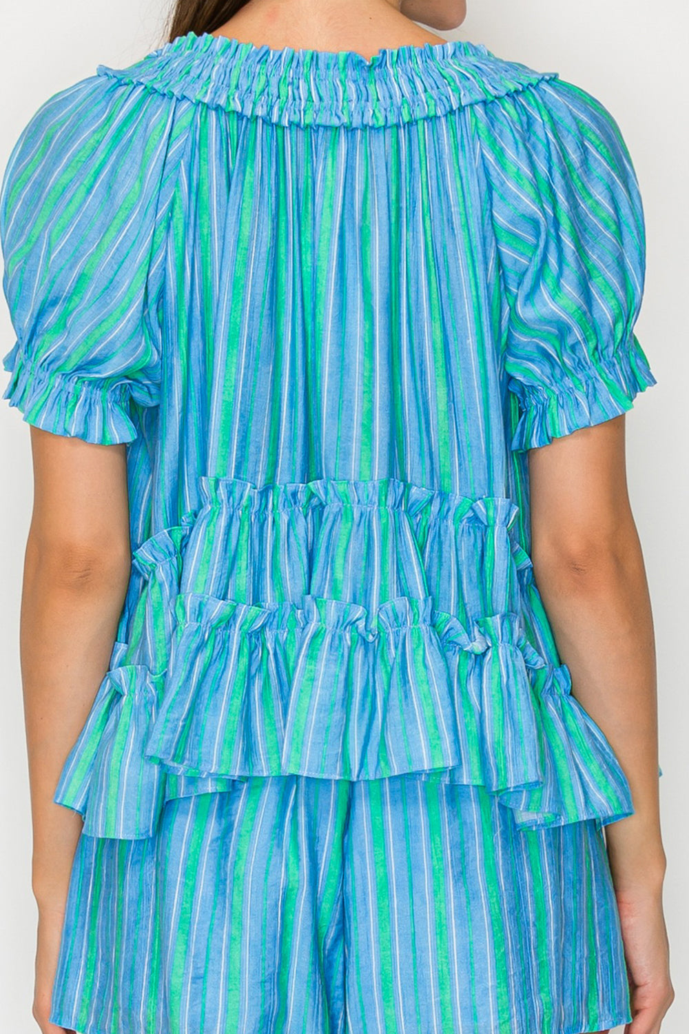 Blue and green striped dress with ruffled layers on a plain background