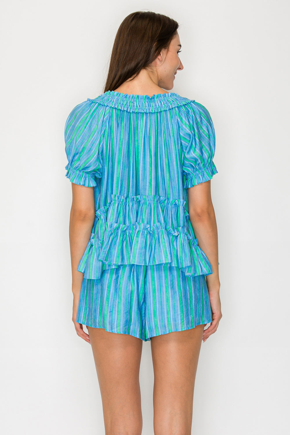 Woman wearing a blue and green striped outfit on a white background