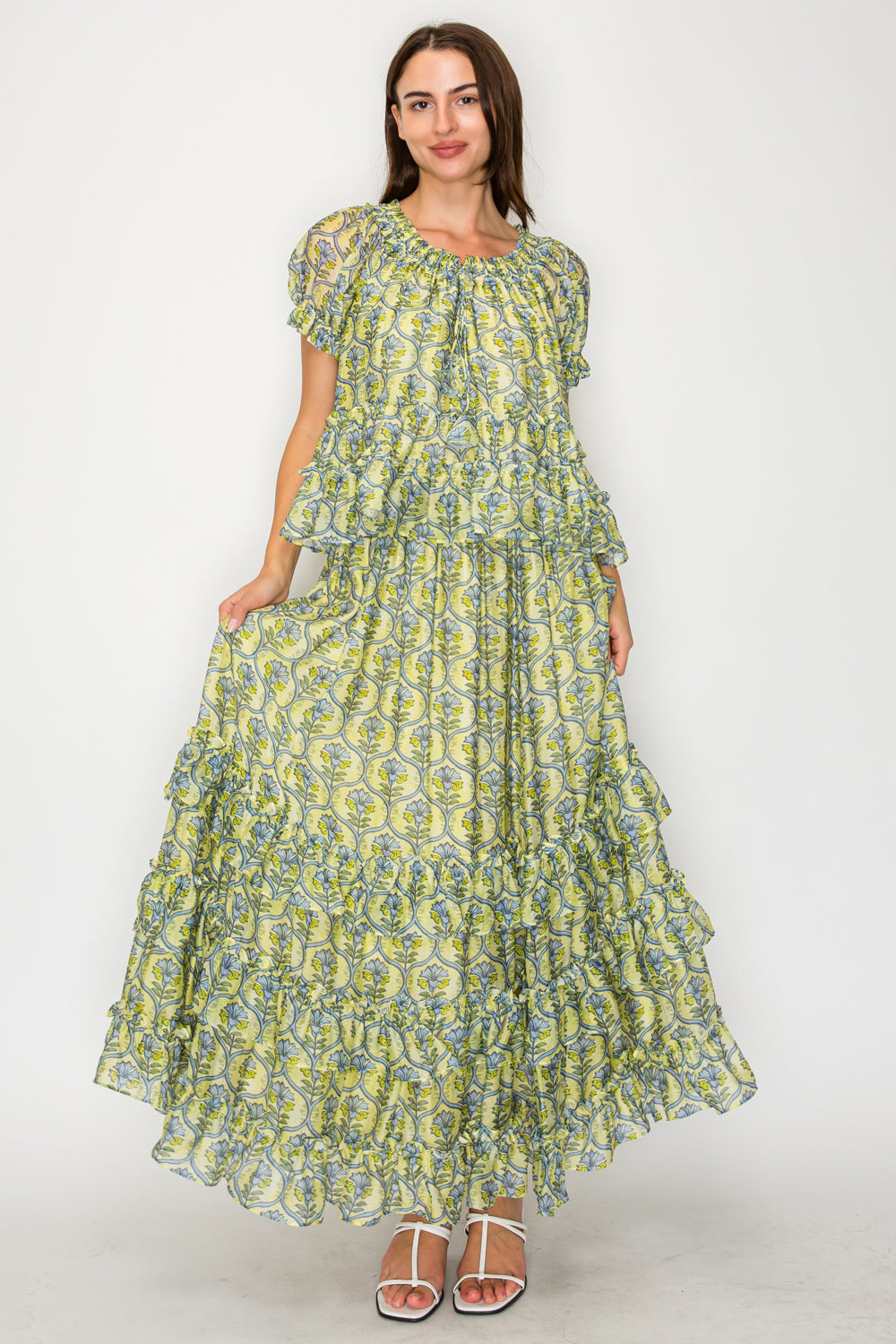 Woman wearing a green floral dress on a white background