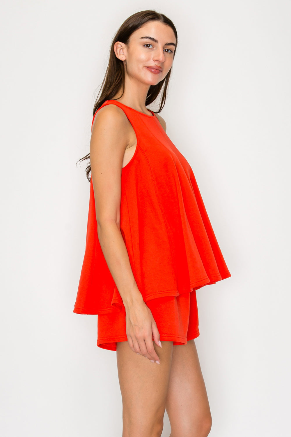 Woman wearing a bright orange dress against a white background